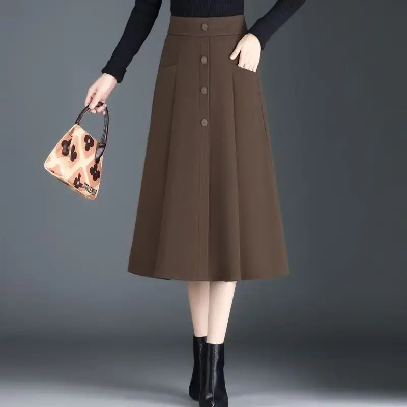 Nuove gonne a pieghe tinta unita alla moda con tasche con bottoni a trapezio elastiche a metà corpo da donna di media lunghezza autunno e inverno 3