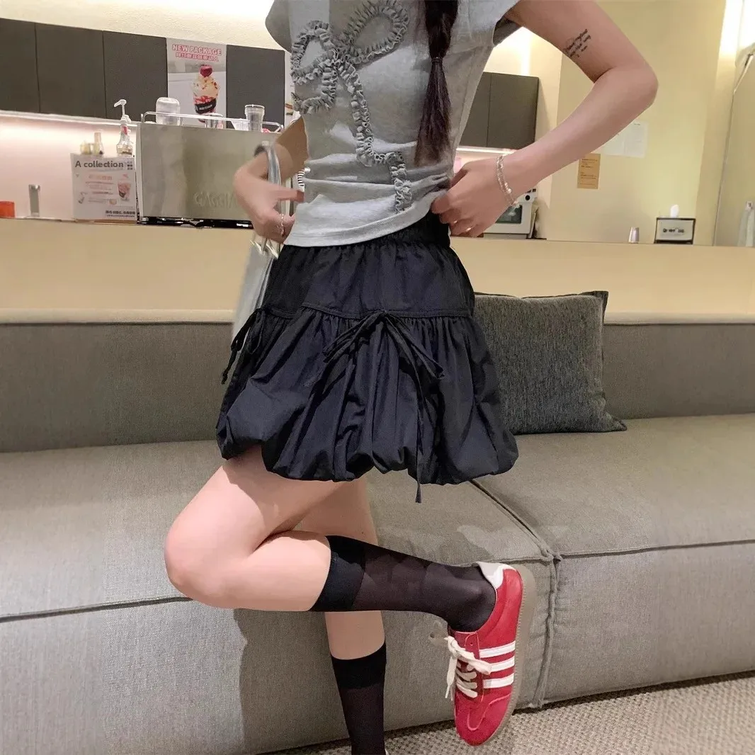 Minigonna a trapezio a vita alta nuovo stile estivo con design a nodo a farfalla Gonna corta a pieghe con torta francese Gonna corta in fibra di poliestere 1