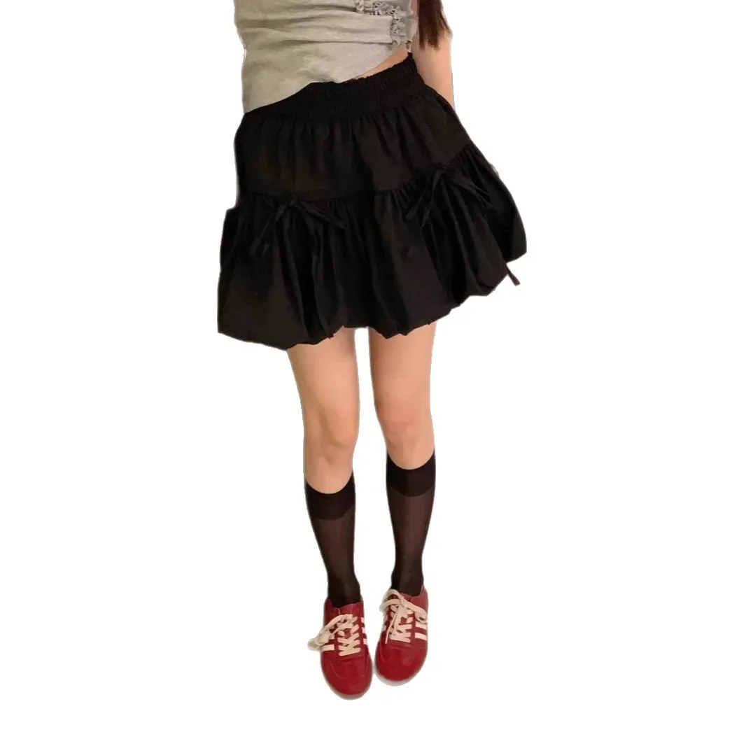 Minigonna a trapezio a vita alta nuovo stile estivo con design a nodo a farfalla Gonna corta a pieghe con torta francese Gonna corta in fibra di poliestere 5